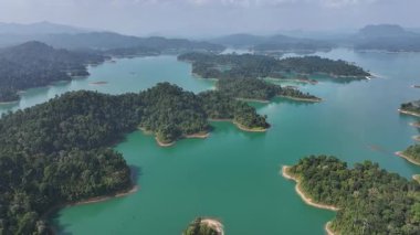 Tayland 'da mavi su ve ağaçlarla kaplı adaların olduğu göl manzarası..