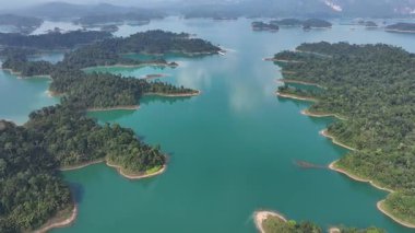 Tayland 'da mavi su ve ağaçlarla kaplı adaların olduğu göl manzarası..