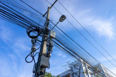 Kabloların düzensizliğini gösteren bir elektrik direği..