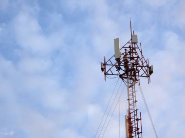 Mavi gökyüzü ve beyaz bulutlu telekomünikasyon kulesi, teknoloji arka planı        