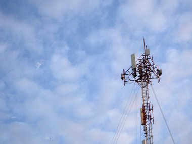 Mavi gökyüzü ve beyaz bulutlu telekomünikasyon kulesi, teknoloji arka planı        