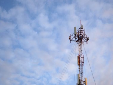 Mavi gökyüzü ve beyaz bulutlu telekomünikasyon kulesi, teknoloji arka planı        