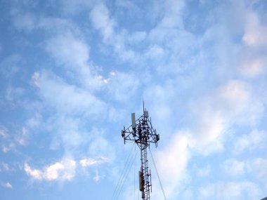 Mavi gökyüzü ve beyaz bulutlu telekomünikasyon kulesi, teknoloji arka planı        