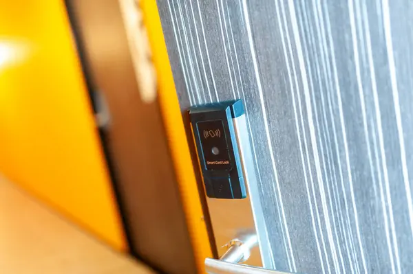 Close up of the door handle of a hotel room with door card .