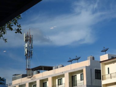 Mavi gökyüzü ve beyaz bulutlu telekomünikasyon kulesi, teknoloji arka planı.                         