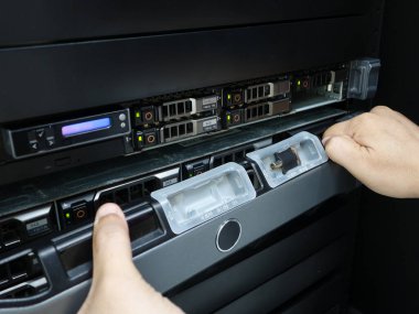 Veri merkezi odasında sunucuyu tamir eden adam .                