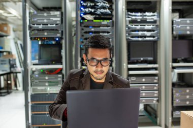 Veri merkezi odasında sunucuyu tamir eden adam .                