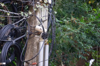 Kabloların düzensizliğini gösteren bir elektrik direği..