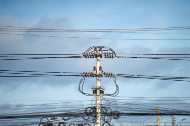 Kabloların düzensizliğini gösteren bir elektrik direği..