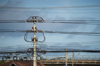 Kabloların düzensizliğini gösteren bir elektrik direği..