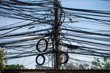Kabloların düzensizliğini gösteren bir elektrik direği..