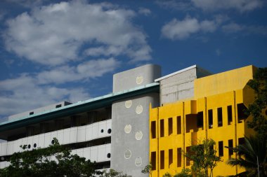 Parlak, bulutlu bir gökyüzüne karşı renkli cephelere sahip modern binaların çarpıcı manzarası. Görüntü, eşsiz mimari ayrıntıları ve canlı estetiği yakalıyor..