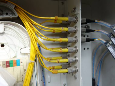Bir ağ kontrol panelinde fiber optik kabloların ve konnektörlerin kapatılması, verimli veri iletimi ve iletişim sistemleri için teknolojinin gösterilmesi.