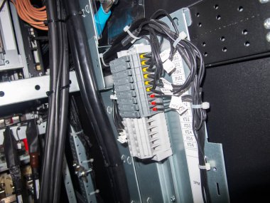 Bu resim, endüstriyel uygulamalar için kablolama, bağlantı ve modülleri vurgulayan bir elektrik kontrol panelinin yakın görüntüsünü gösterir..