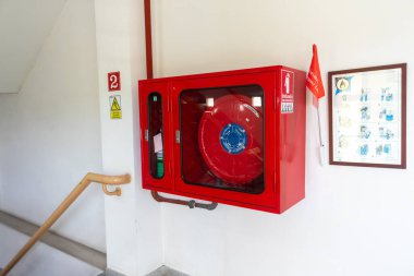 Bu görüntüde yangın söndürme ünitesi bir bina merdivenine monte edilmiş ve gerekli yangın güvenlik ekipmanları ve acil durum önlemlerini vurguluyor..