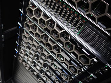 LED göstergelerle donatılmış çoklu ağ sunucularının yer aldığı modern bir veri merkezi rafının yakın görüntüsü. Bu görüntü dijital altyapıdaki gelişmiş teknolojiyi temsil ediyor..