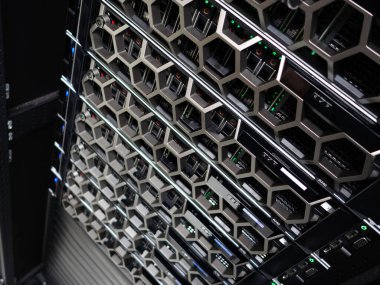 LED göstergeleriyle aydınlatılmış birden fazla donanım birimini gösteren modern bir sunucu rafının yakın plan görüntüsü, veri merkezi ortamında gelişmiş teknoloji sergileniyor.