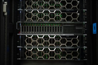 Yüksek teknolojili bir veri merkezi sunucu rafının yakın görüntüsü. Gelişmiş sunucu teknolojisi, metalik tasarım ve parlayan yeşil göstergeler. Teknoloji odaklı platformlar için ideal.