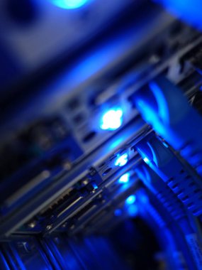 Mavi LED ışıklarla aydınlatılan bir sunucu rafının büyüleyici yakın çekimi, modern veri merkezinde gelişmiş teknoloji sergileniyor.