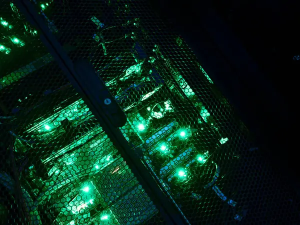 Canlı yeşil aydınlatma, ileri teknoloji ve veri merkezi ortamında karmaşık kablolama içeren bir bilgisayar sunucu rafının yakın çekim görüntüsü.