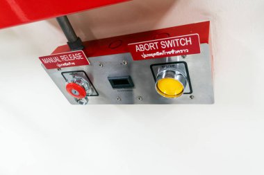 Bu görüntü, endüstriyel ortamlarda güvenlik için hayati önem taşıyan ve acil durumlarda acil müdahale sağlayan bir manuel açma düğmesi ve iptal düğmesinin yer aldığı bir kontrol panelini gösteriyor..
