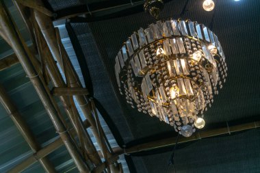 Büyüleyici bir kristal avize, kırsal bir iç mekanı süsler, sıcak bir parıltı yayar ve uzayın zarafetini artırır. Güzelliğini ve sanatını sergilemek için mükemmel.