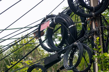 Elektrik kablolarının olduğu elektrik direğinin yakın çekim görüntüsü. Görüntü, kentsel altyapı ve bağlantı için gerekli olan karmaşık kablo ağını gösteriyor.