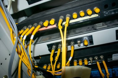 Bir veri merkezi kurulumundaki ağ kablolarının ve bağlantıların yakın plan görüntüsü, organizasyonlarını, işlevselliklerini ve teknoloji altyapısındaki önemini gözler önüne seriyor.