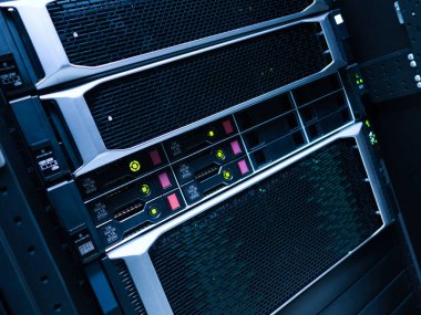 Veri depolama ve ağ yönetimi için tasarlanmış, yanıp sönen ışıklarla gelişmiş teknolojiyi gösteren bir bilgisayar sunucu rafının yakın plan görüntüsü.