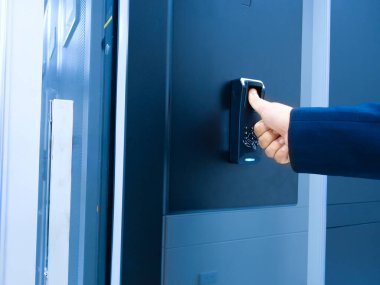 Bir el, güvenliğin arttırılması ve çeşitli ortamlarda mahremiyetin sağlanmasında erişim kontrolünün önemini vurgulayan modern bir elektronik kilit sistemi işletiyor..