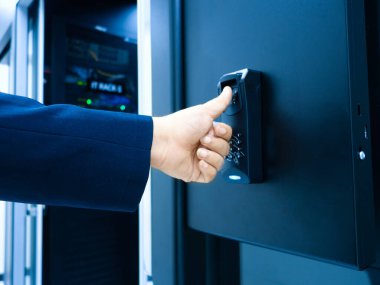 Güvenli bir kasada parmak izi tarayıcısı kullanan bir eli gösteren yakın plan bir resim. Bu biyometrik sistem veri depolama ve erişim kontrolündeki güvenliği arttırır.