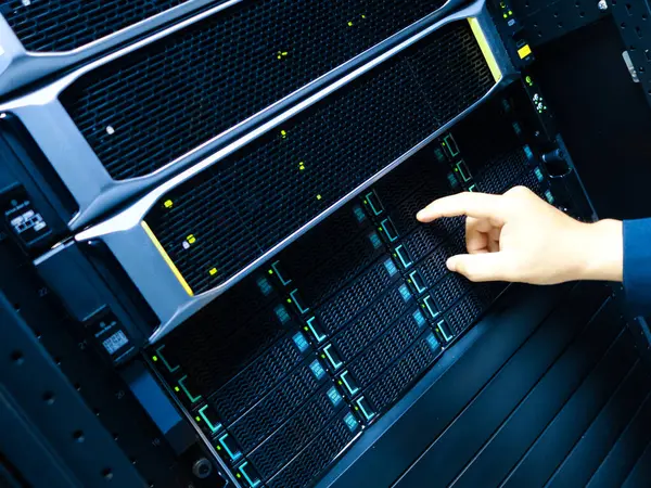 Bir teknisyen, modern teknolojiyi ve veri yönetiminin profesyonel bir çevrede taşıdığı önemi gösteren bir sunucu panelinde bakım yapıyor..