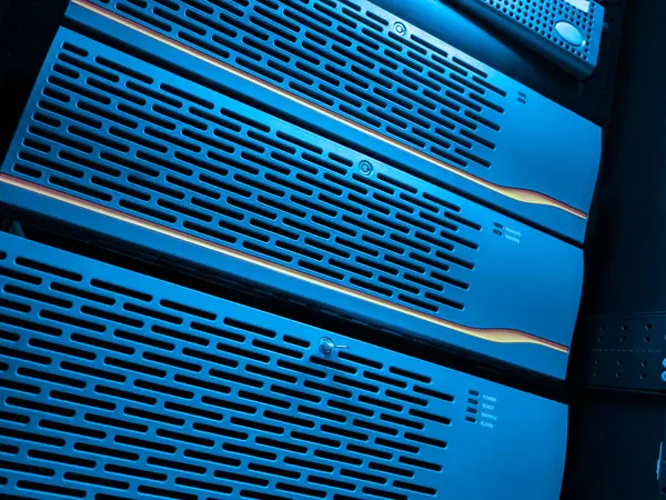 Modern bir veri merkezinde mavi ışıklı bir sunucu rafının yakın plan görüntüsü, gelişmiş teknoloji ve verimli veri depolama ve yönetim için organize donanım sergileniyor.