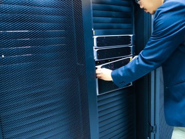 Bir profesyonel modern bir veri merkezinde sunucu ekipmanlarını ayarlar. Bu görüntü bilişim ortamında teknoloji yönetimi ve bakımının özünü yakalar..