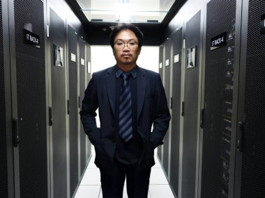 Profesyonel bir bilişim uzmanı, lüks bir sunucu odasında modern teknoloji ve veri yönetimi ve ticari işlemler için gerekli güvenlik sistemlerini sergileyerek güvenle poz veriyor.