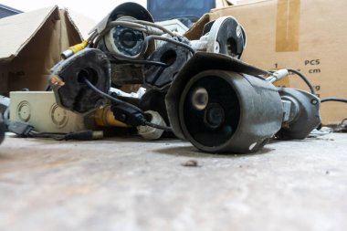 Atılmış elektronik ve kabloların kentsel bir çevreye yakın çekim görüntüsü. Bu resim teknolojide geri dönüşümün ve uygun atık yönetiminin önemini vurgular.
