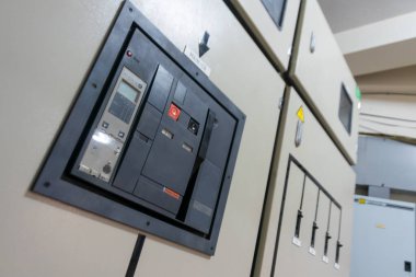Endüstriyel bir ortamda elektrik kontrol panelinin detaylı bir görüntüsü, güç dağıtımı ve güvenlik operasyonlarının yönetiminde kullanılan bileşenleri ve tasarımı gösteriyor.