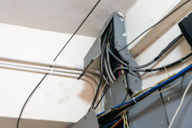 Kentsel altyapı ortamında bir kablo yönetimi kurulumunun yakın plan görüntüsü, çeşitli kabloları ve kanalları stratejik olarak düzenleyerek verimli elektrik işlemleri ve güvenlik için düzenlenmiştir..