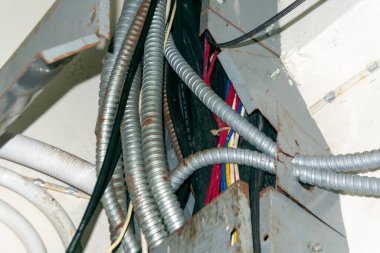 Bu görüntü, endüstriyel ortamlarda güvenlik, organizasyon ve bakım potansiyelini vurgulayan bir kanal sistemi içinde elektrik kablolarının ve kabloların karmaşık bir düzenini gösteriyor..