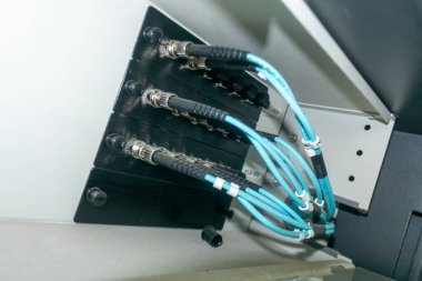 Donanıma bağlı fiber optik kabloların yakın görüntüsü, telekomünikasyon ağlarında yüksek hızlı veri transferi için modern teknolojiyi sergiliyor.