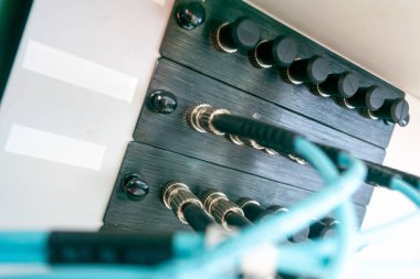 Çağdaş üretim ortamlarında ses ekipmanları ve teknolojiyi resmetmek için mükemmel olan düğme ve kabloların yer aldığı bir kontrol panelinin yakın görüntüsü.