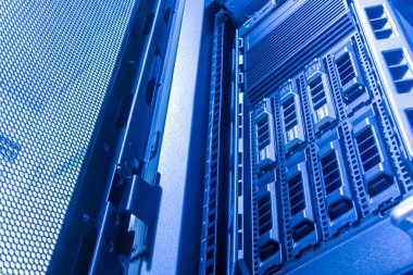 Mavi ışıklarla aydınlatılan, bilgisayar teknolojisindeki yenilik ve bağlantıyı vurgulayan, yüksek teknolojili sunucu raflarını gösteren modern bir veri merkezinin içini araştırın..