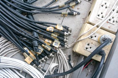 Elektrik tesisatlarının karmaşıklığını vurgulayan elektrik bantlarına bağlı karmaşık kablolar ve etiketlenmiş kabloların yakın plan görüntüsü.