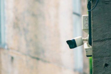 Bir binanın duvarına monte edilmiş, kentsel bir ortamda modern gözetleme teknolojisini gösteren, güvenlik ve izleme kapasitesini arttıran bir güvenlik kamerası..