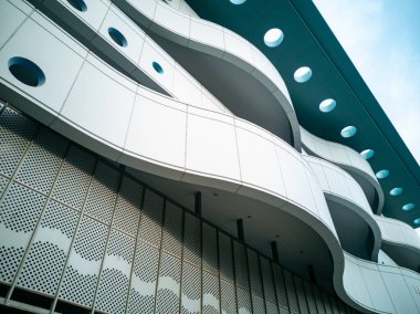 Çarpıcı bir görsel etki yaratan akış çizgileri ve geometrik desenler içeren çağdaş bir mimari tasarımın karmaşık detaylarını araştırın.