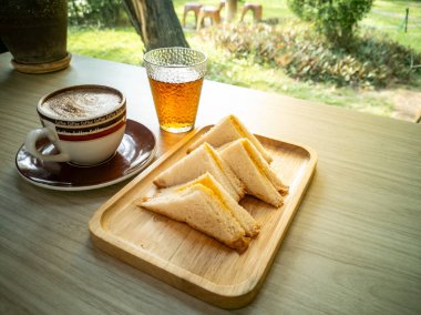 Bir fincan kahve ve çayla birlikte sandviçlerin olduğu rahat bir ortam. Kahvaltı için mükemmel ya da doğal bir ortamda öğle yemeği için..