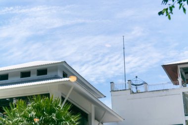 Parlak mavi gökyüzüne karşı parlak çizgiler ve minimalist tasarımın yer aldığı modern mimari bir sahne, çağdaş yaşam alanları veya kentsel gelişim için mükemmel.