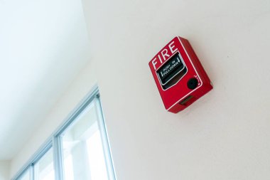 Duvara monte edilmiş kırmızı yangın alarmı önemli güvenlik önlemleri sağlar. Acil durumlar için gereklidir, hızlı eylem sağlar ve kullanıcıları alarma geçirir.