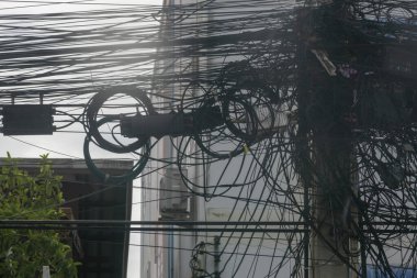 Şehir ortamında karmaşık elektrik kabloları ve kablolar, modern altyapının karmaşıklığını gözler önüne seriyor..