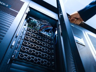 Modern bir veri merkezindeki sunucu rafının yakın plan görüntüsü, düzgün organize edilmiş kabloları ve gelişmiş donanımı gösteriyor, yüksek performanslı teknolojiyi temsil ediyor..